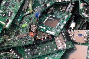A heap of discarded electronic circuit boards, showcasing various components and connectors, emphasizes e-waste management and recycling challenges.