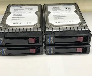 Four data storage hard drives are stacked in two rows, each labeled for identification. The image illustrates server hardware used for data management.