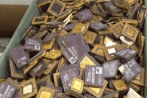A large pile of old computer chips and processors in a container, highlighting the obsolescence of technology and electronic waste management.