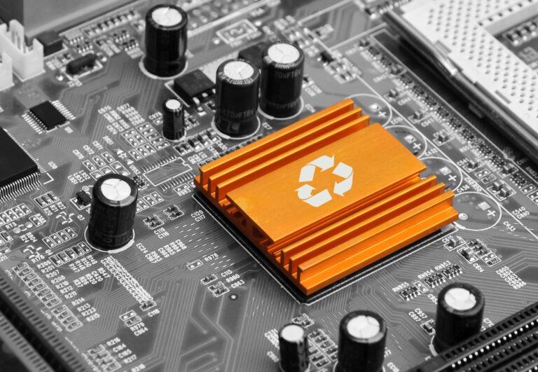 Orange heatsink with a recycling symbol on a circuit board, highlighting eco-friendly technology in electronics.